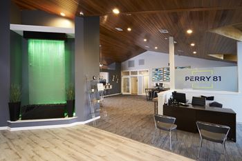 A modern office space with a green accent wall and a sign that reads "PERRY 81".